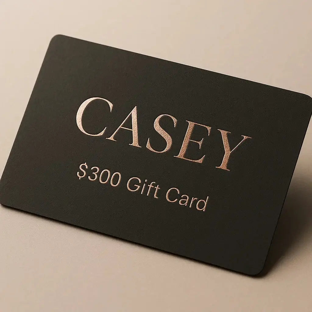 Black gift card with 'CASEY' and '$300 Gift Card' text on a beige background